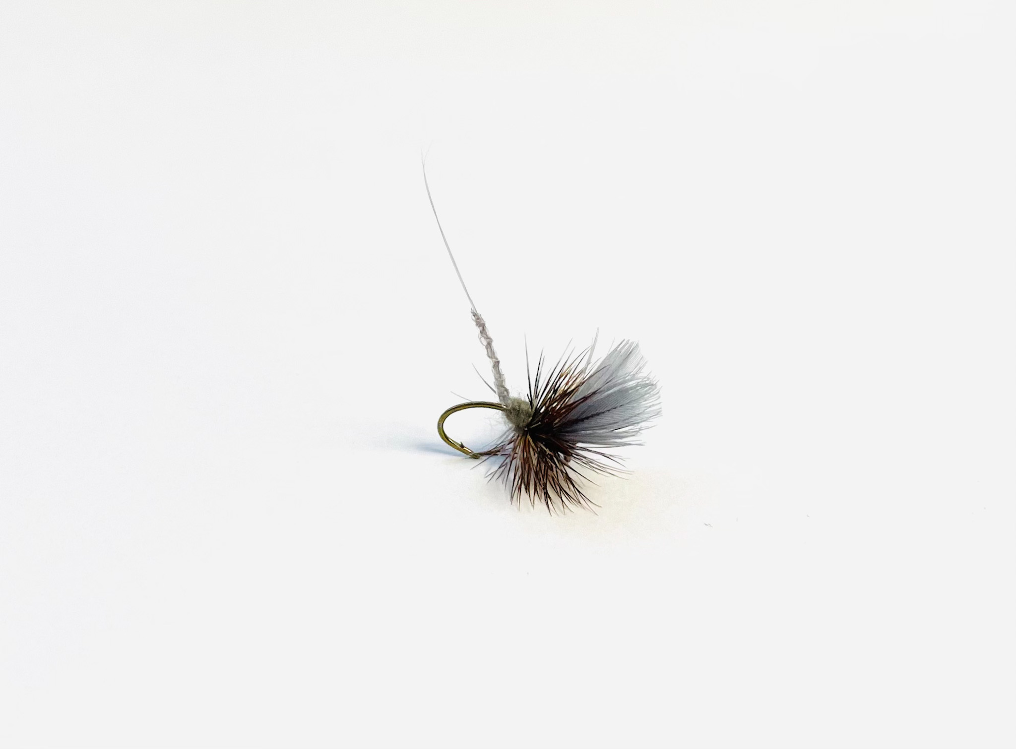 Extended body Adams dry fly pattern imitating mayfly duns for trout fishing.